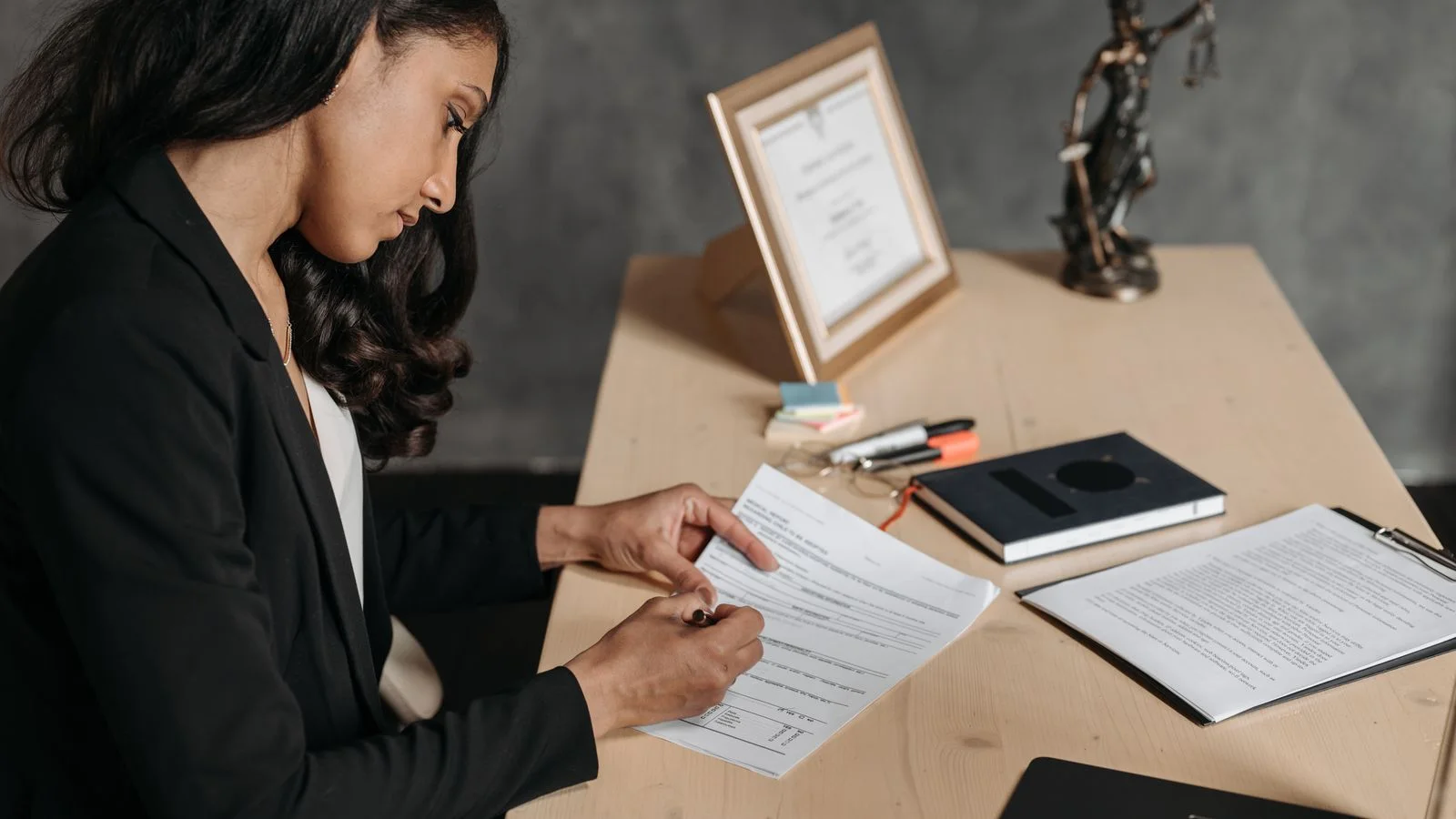 A legal professional reviewing regulatory documents at an office desk.