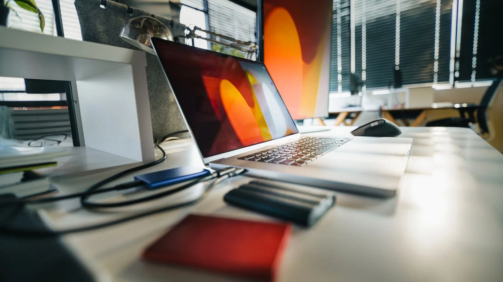 A professional laptop workspace with external storage devices, representing controlled access to sensitive financial data.