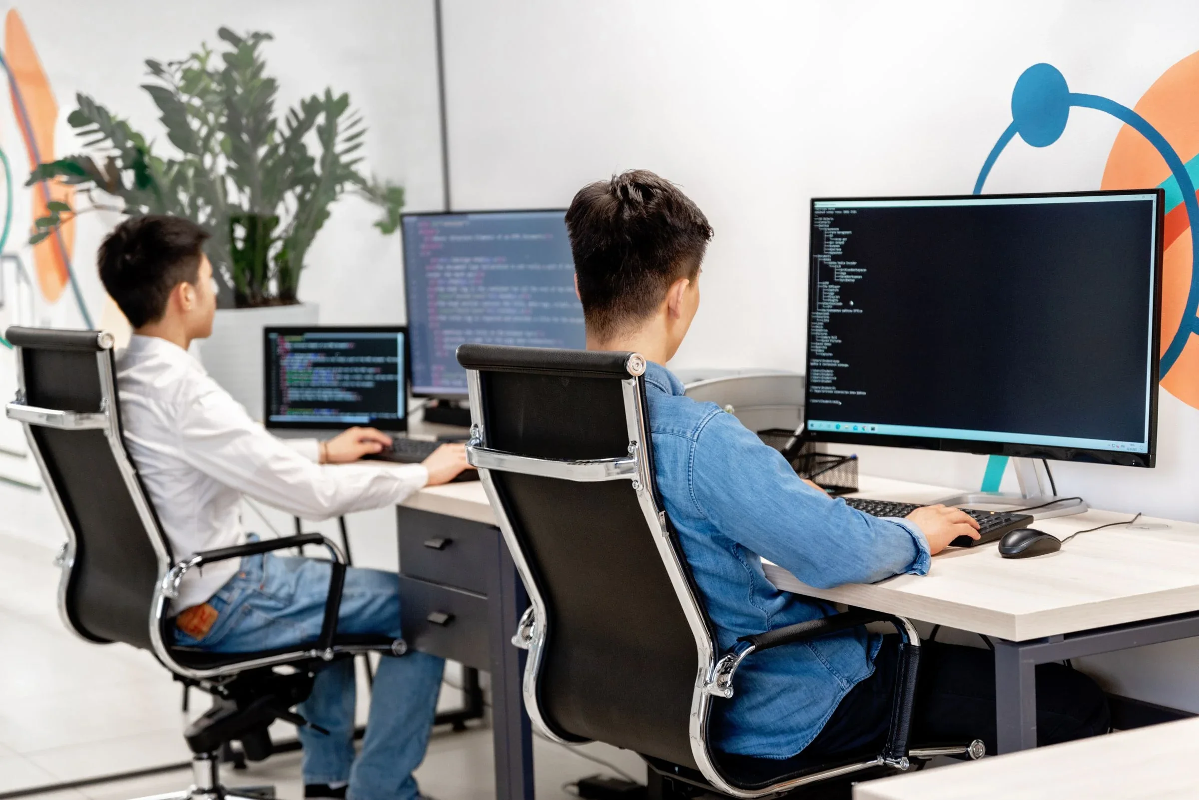Software developers working at computers in a modern office.
