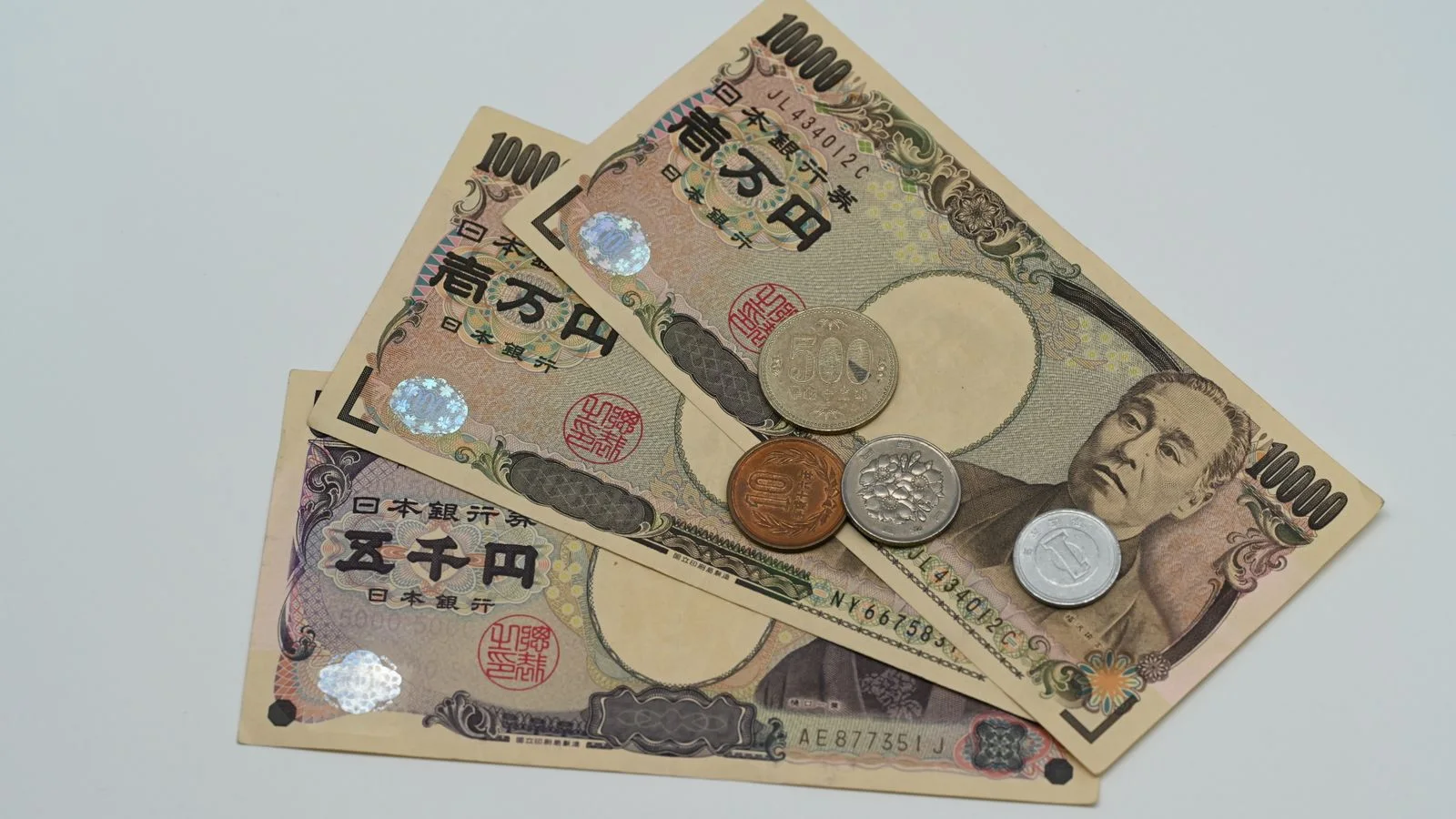 Japanese yen banknotes and coins arranged on a desk, representing yen-funded carry trades and global liquidity.